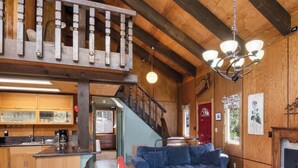 A spacious living area with a fireplace, a dining area, and a kitchen.
