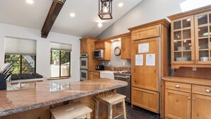 Una cocina moderna con armarios de madera, encimera de granito y electrodomésticos de acero inoxidable.