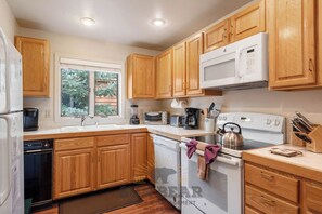 A kitchen with wooden cabinets, a microwave, a toaster, a kettle, and a dishwasher. - 2 Bedroom close to Hyatt w Complex Hot Tub (MC154) (Incline Village)