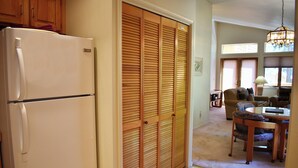 A kitchen with a white refrigerator, wooden louvered closet doors, a dining area with a table and chairs, and a chandelier. - 1 Bedroom close to Hyatt w Complex Hot Tub (MC254) (Incline Village)