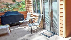 A patio with a covered grill, outdoor seating, and a sliding glass door. - 1 Bedroom close to Hyatt w Complex Hot Tub (MC254) (Incline Village)