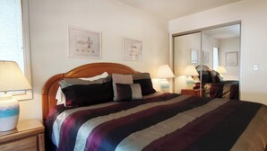 A neatly made bed with a striped blanket, two bedside lamps, and a vase on the nightstand. - 1 Bedroom close to Hyatt w Complex Hot Tub (MC254) (Incline Village)