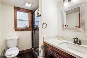 A bathroom with a toilet, a shower, a sink with a mirror, and a window above the toilet. - 3 Bedroom Open Space Condo (IC3-72) (Incline Village)
