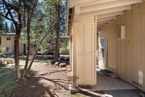 A building with a covered entrance, a gravel path, and trees.