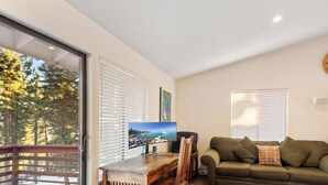 A living room with a television, a couch, and a wooden table. - 3 Bedroom w Hot Tub and Forest Views (829EL) (Incline Village)