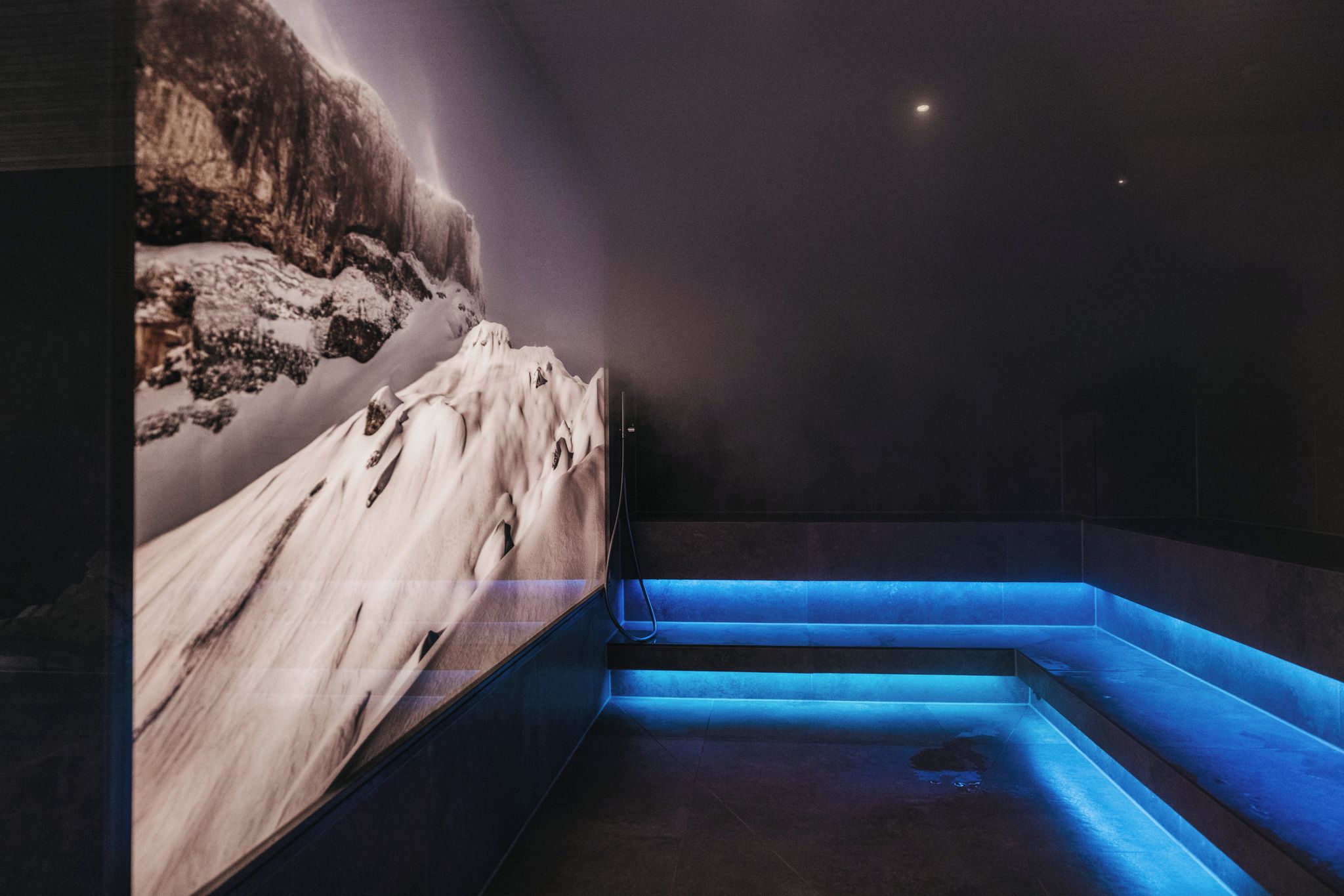 A spa area with a snow-themed wall and blue-lit steps.