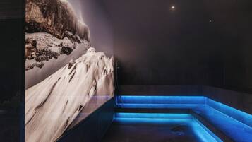 A spa area with a snow-themed wall and blue-lit steps.