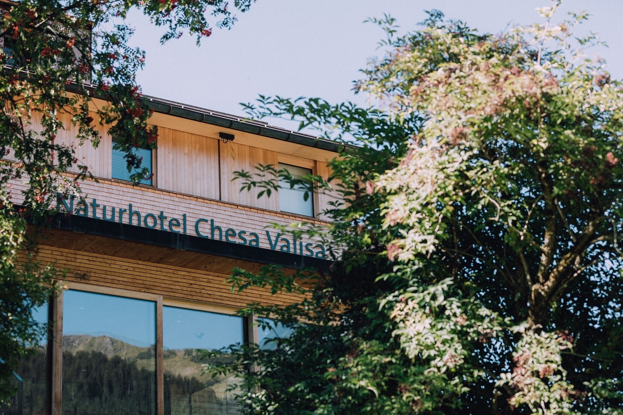 Un bâtiment moderne sur lequel on peut lire l’inscription : « Naturhotel Chesa Valisa ».