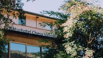 Un bâtiment moderne sur lequel on peut lire l’inscription : « Naturhotel Chesa Valisa ».