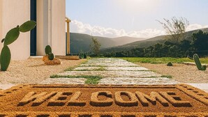 A modern building with a clear sky and a welcome mat in front. - Silenza B&B (Mattinata)