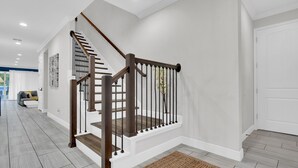 A modern staircase with wooden railings and white walls.