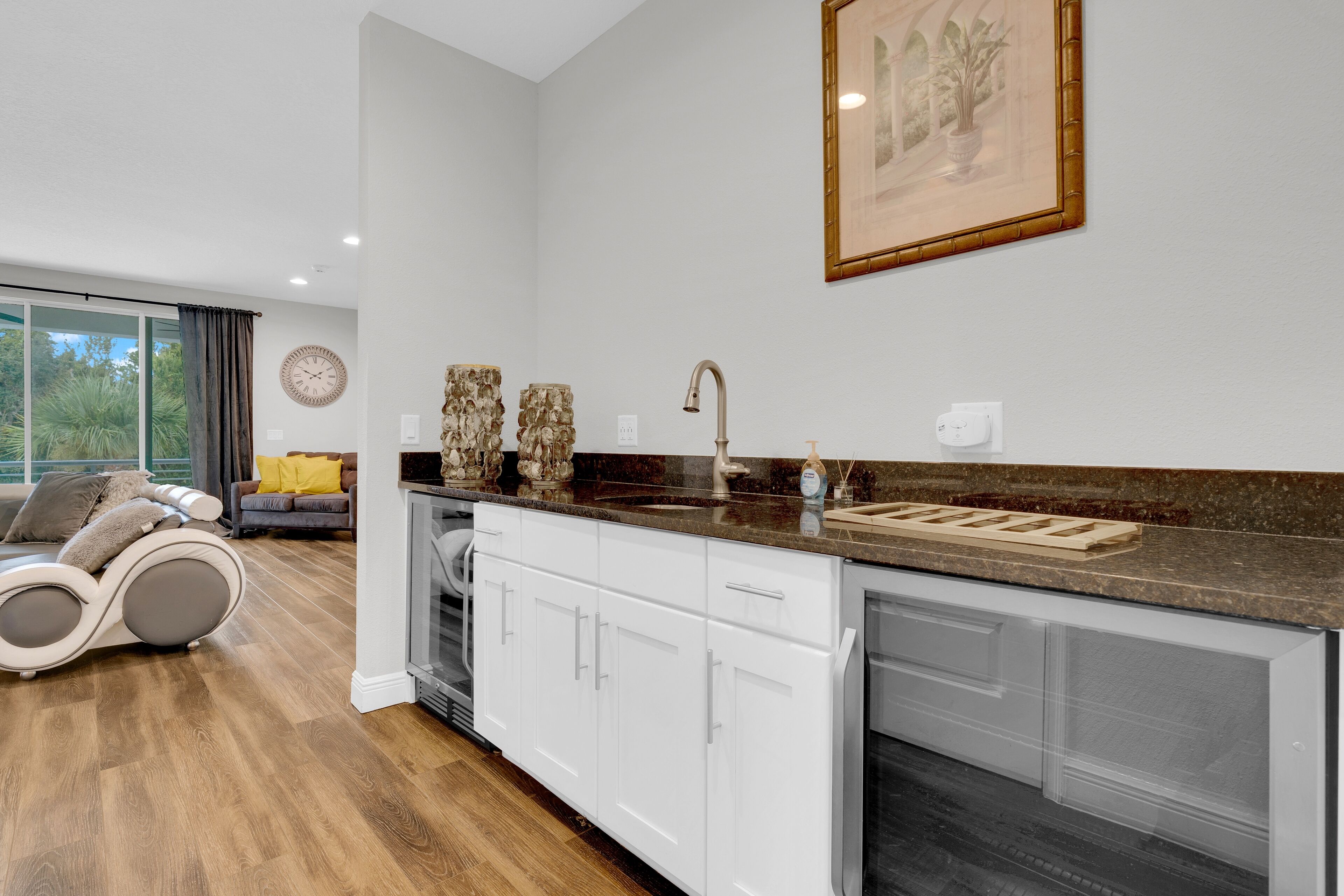 A modern kitchen with white cabinets, a granite countertop, and a built-in dishwasher.