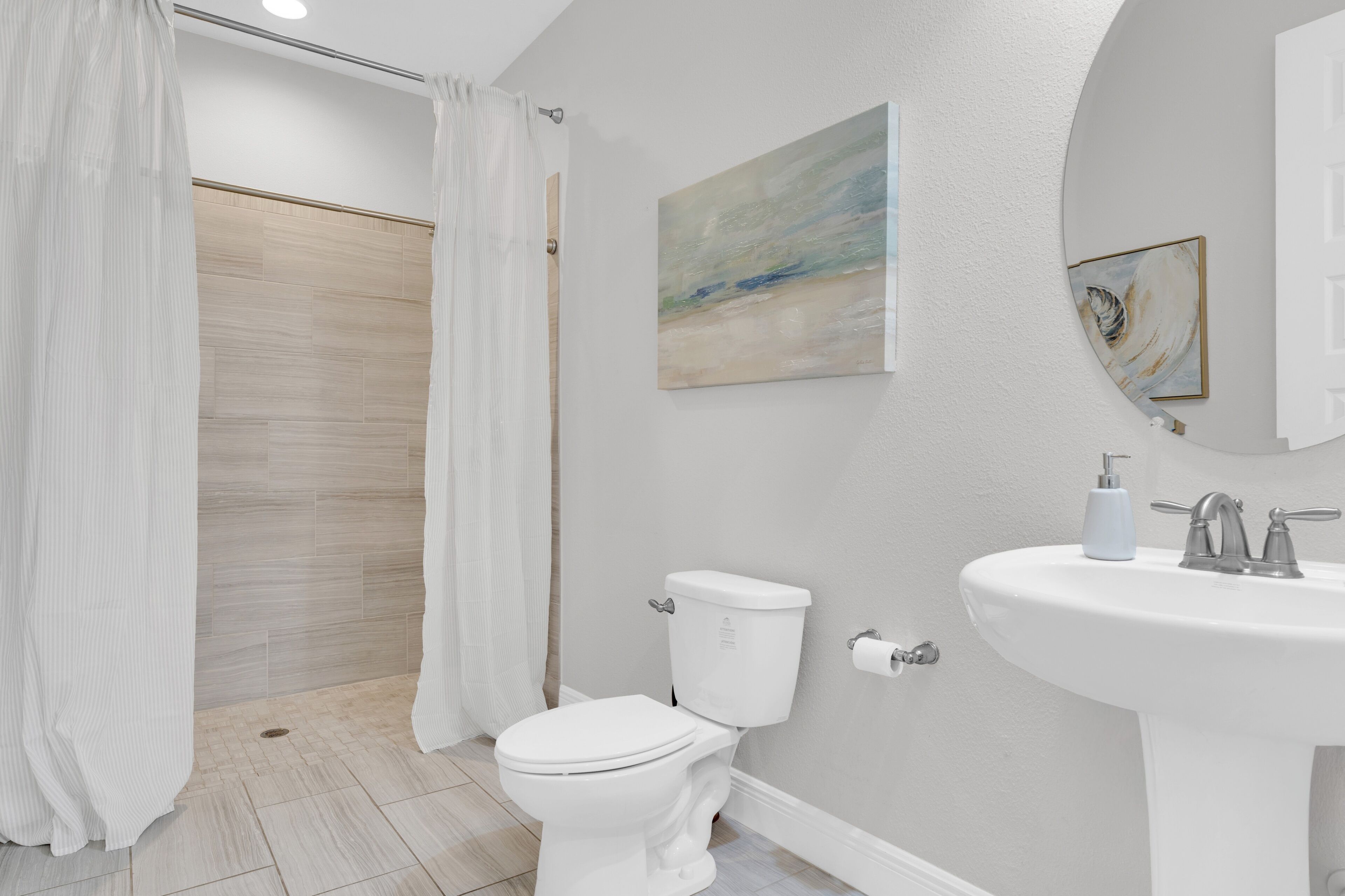 A bathroom with a toilet, sink, and shower curtain.
