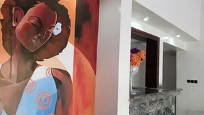 A reception area with a marble counter and a large abstract painting on the wall. - Hubbies Royale Hotel (Owerri)