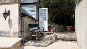 A narrow stone pathway leading to a wooden door labeled "The Nest."