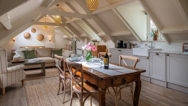 A cozy loft-style living space with a dining area, kitchen, and seating area.