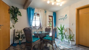 A dining area with a round table, four chairs, and a potted plant. - Kleingesee approx. 5 km from Gössweinstein Holiday apartment Haus Sonnenscheim (Gößweinstein)