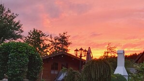 A rustic cabin with a chimney, surrounded by lush greenery and a bench. - Kleingesee approx. 5 km from Gössweinstein Holiday apartment Haus Sonnenscheim (Gößweinstein)