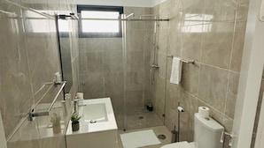 Un bagno moderno con doccia, WC e lavandino.
