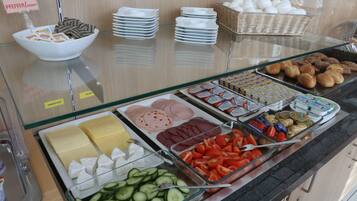 A buffet with various food items, including sliced meats, cheeses, and vegetables.