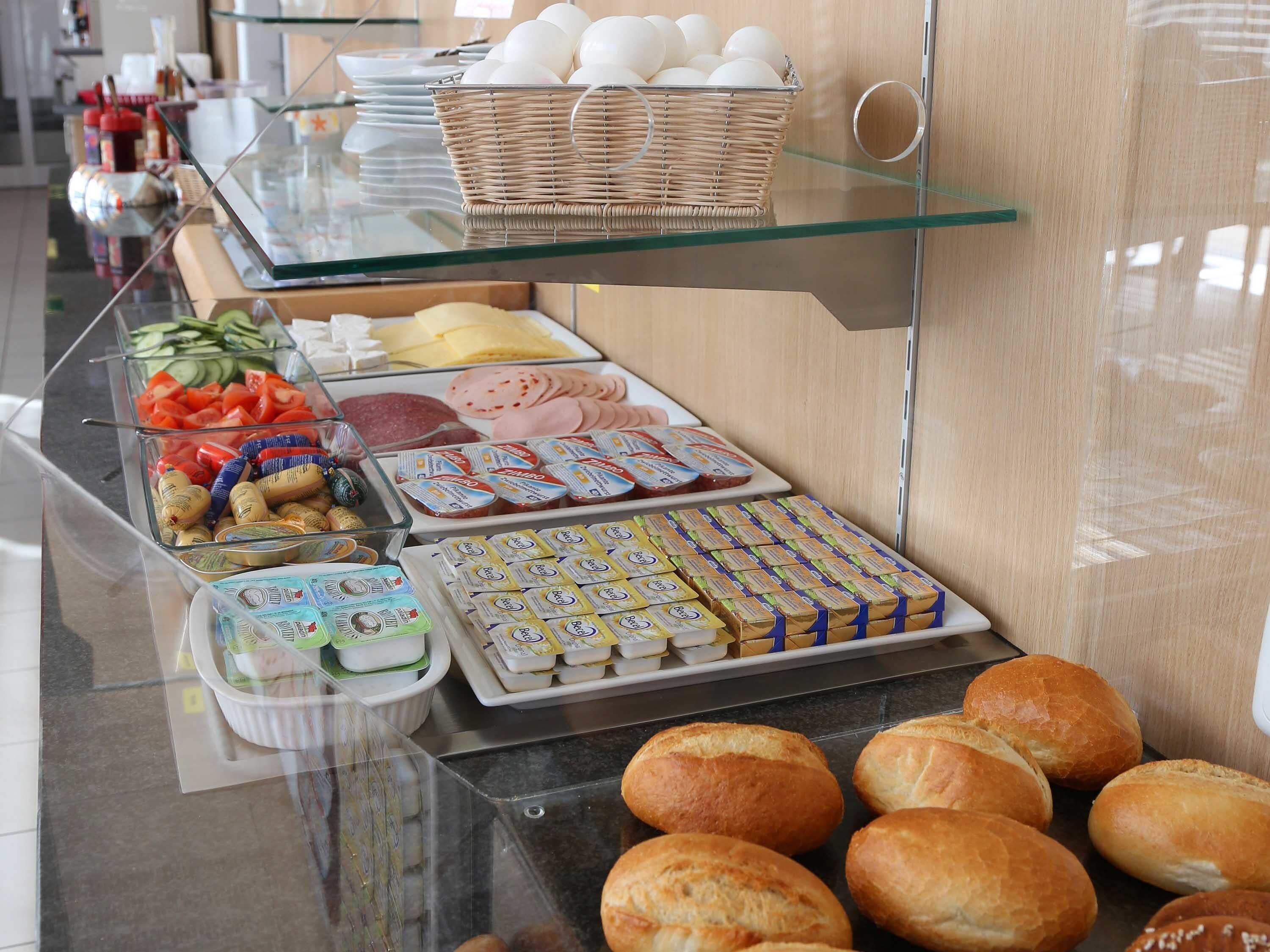 A buffet with various food items including bread, eggs, and dairy products.