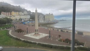 A coastal town with a prominent monument in the center, a promenade along the sea, and a variety of buildings in the background. - Seaview 2 Double bed Apartment 2nd Floor (Llandudno)