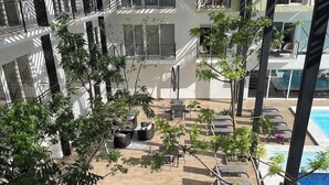 En tagterrasse med liggestole, et lille bord og plantekrukker.