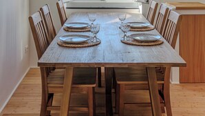 A dining table with placemats and glasses, set against a large window with a view of the sea. - Newly Renovated Ocean View Flat (Sori)
