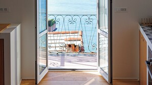 An open door leading to a balcony with a view of the sea. - Newly Renovated Ocean View Flat (Sori)