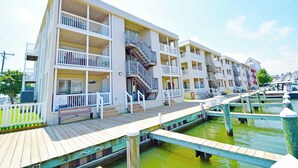 Un hôtel situé au bord de l’eau, doté de nombreux balcons, d’une terrasse en bois et d’un quai s’avançant dans l’eau.