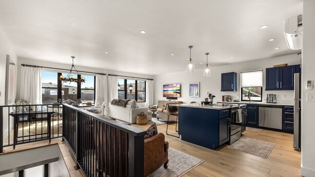 A spacious living area with a large island, a dining area, and a kitchen with modern appliances.