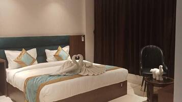 Una camera d'albergo moderna con un letto grande, una ventola a soffitto e una tenda scura.