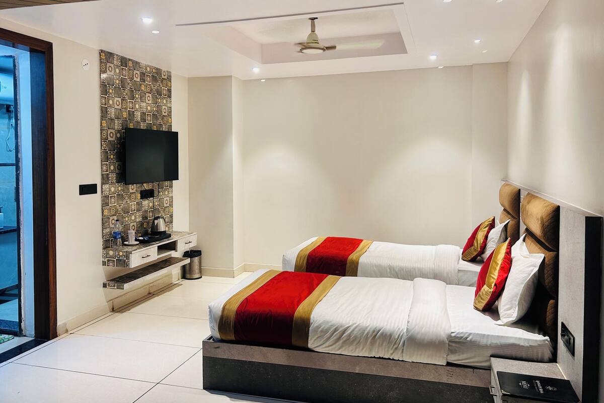 Un dormitorio moderno con una cama, un televisor y una pequeña mesa.