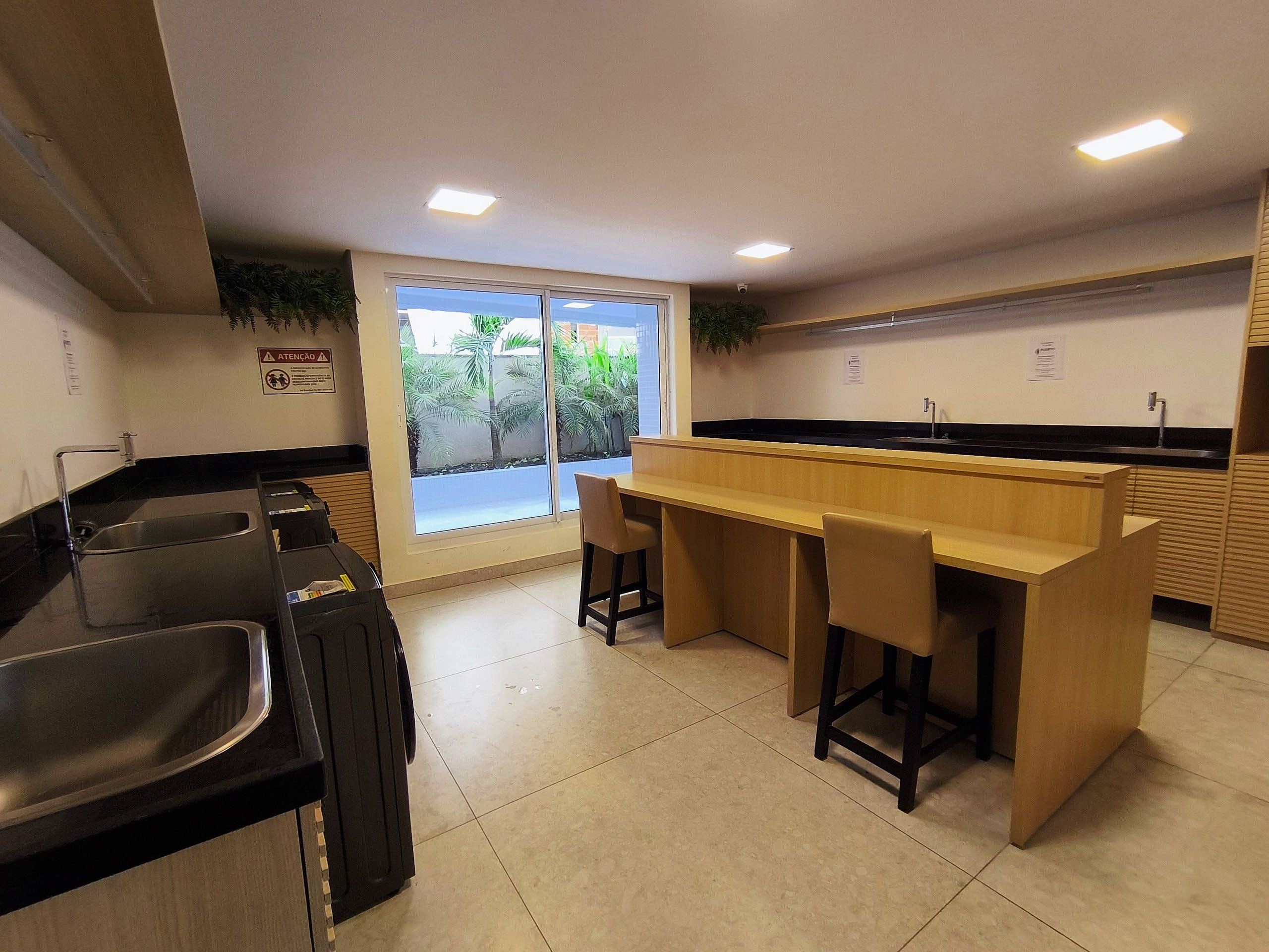 Una cocina moderna con una isla central, un fregadero y una ventana con vistas a zonas verdes.