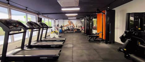 A gym with treadmills, exercise bikes, and weight machines.