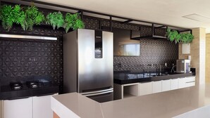 A modern kitchen with a black textured backsplash, stainless steel appliances, and a white countertop.
