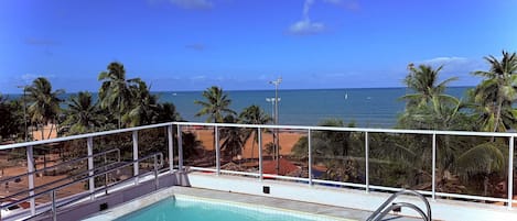 A swimming pool with a view of the beach and ocean.