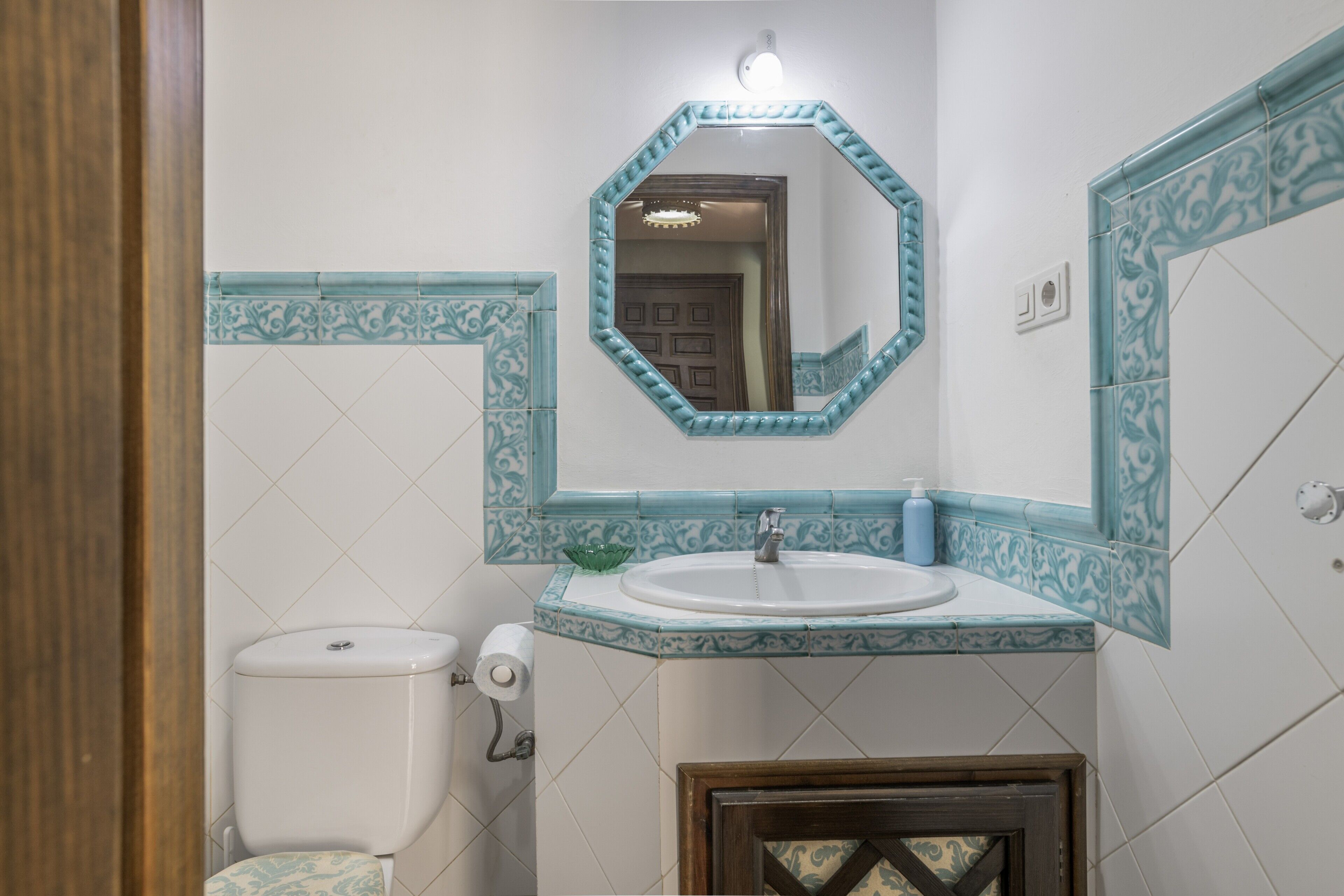 Une salle de bain avec des toilettes, un lavabo et un miroir.