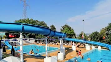 A swimming pool area with multiple pools and a water slide.
