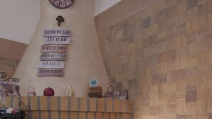 Un camino con rivestimento in mattoni, un orologio sopra e un cartello con regole di vita.