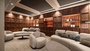 Una sala moderna con estanterías empotradas de madera, un sofá modular y una mesa de centro redonda.