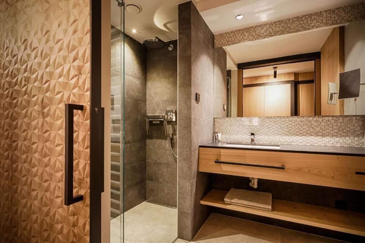 A modern bathroom with a shower, a vanity with a mirror, and a towel rack.