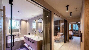 Un baño moderno con cabina de ducha de vidrio, tocador doble y un espejo grande.