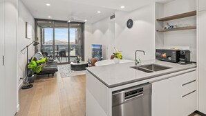 Una cocina moderna con una isla central, electrodomésticos integrados y un comedor con vistas.