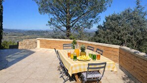 An outdoor patio with a checkered tablecloth, a pineapple, and various drinks. - EXCEPTIONAL VIEW of Mt. Ventoux, between the Ardèche Gorges and the Cèze Valley (Salazac)