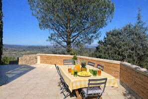 An outdoor patio with a checkered tablecloth, a pineapple, and various drinks. - EXCEPTIONAL VIEW of Mt. Ventoux, between the Ardèche Gorges and the Cèze Valley (Salazac)