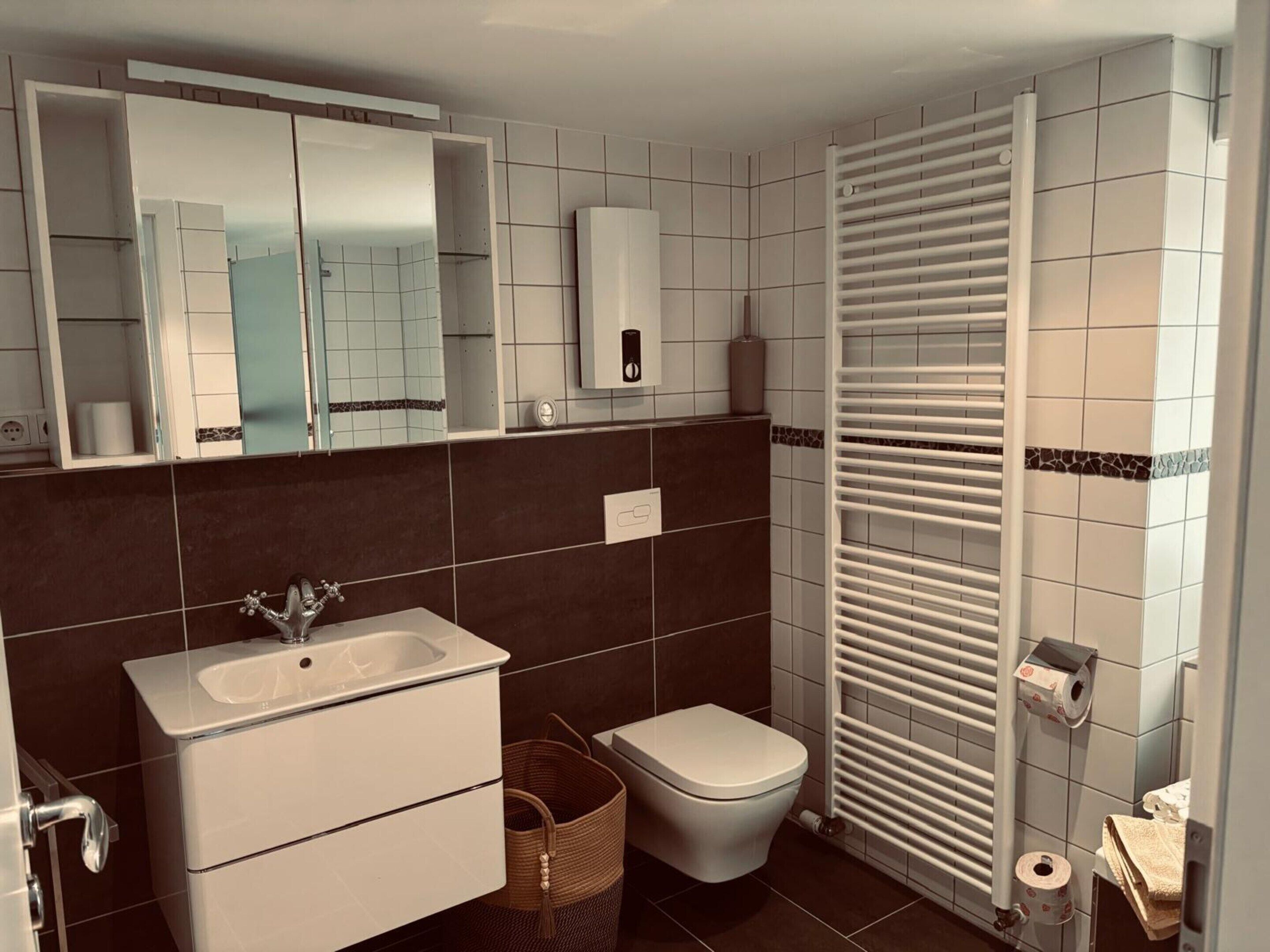Ein modernes Badezimmer mit Waschbecken, Toilette und Handtuchhalter.