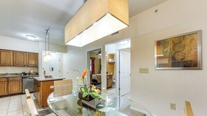 A modern kitchen with wooden cabinets, a glass dining table, and a pendant light. - Poolside Bliss & Theme Park Thrills: Orlando Oasis (Orlando)