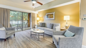 A modern living room with a ceiling fan, a sofa, a coffee table, and a lamp. - Poolside Bliss & Theme Park Thrills: Orlando Oasis (Orlando)