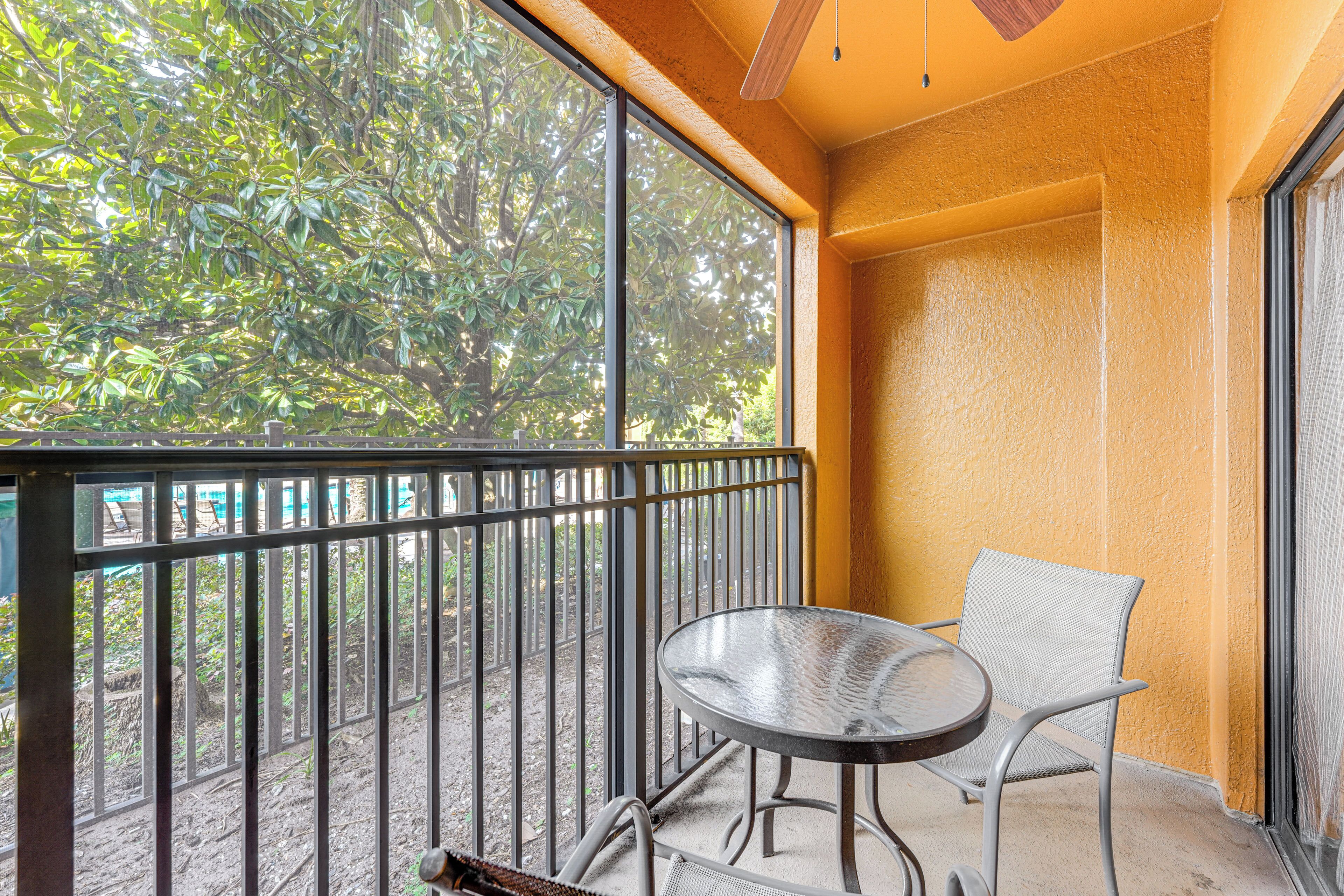 Ein Balkon mit Metallgeländer, einem runden Tisch und einem Stuhl.
